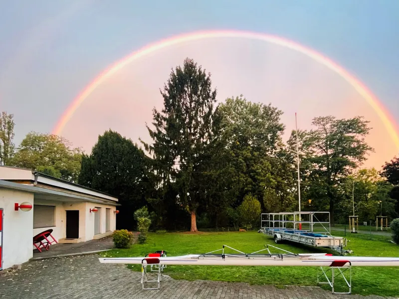 Doppelter Regenbogen über Bootshaus und Garten der FRGS, davor ein Rennvierer auf Böcken