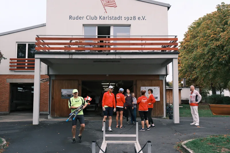 Start am Bootshaus des Ruder-Clubs Karlstadt 1928: Ruderer mit Skulls vor der Bootshalle